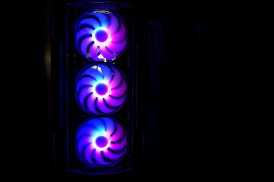 Trois ventilateurs RGB illuminés en bleu et violet au sein d'un boîtier pour un comparatif: carte graphique performante.