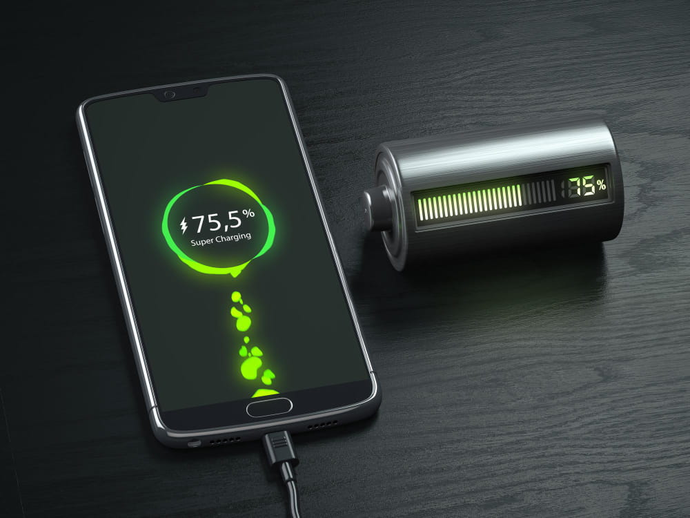 Smartphone moderne posé sur une table sombre affichant une charge rapide de 75,5% avec une icône de batterie stylisée à côté