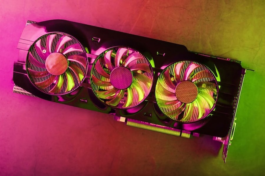 Une carte graphique de gaming à trois ventilateurs sous un éclairage néon pour des comparatifs carte graphique.