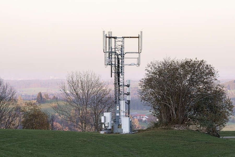 Antenne relais de télécommunications située sur une colline verdoyante pour assurer la couverture d'un forfait 5g réseau orange en zone rurale.